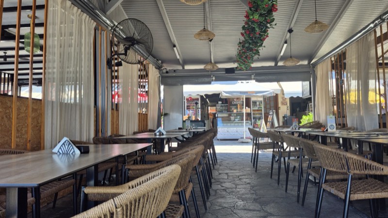 The covered terrace dining room with its wicker lamps