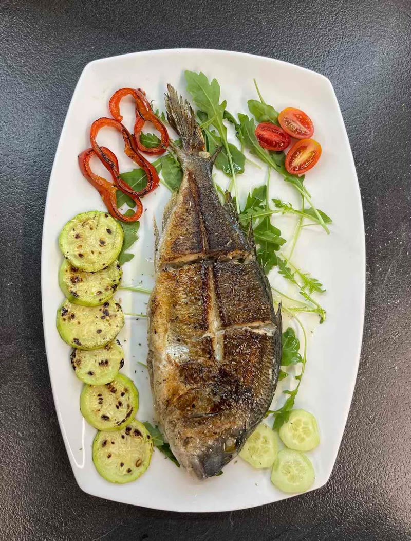 Whole grilled dorada with vegetables